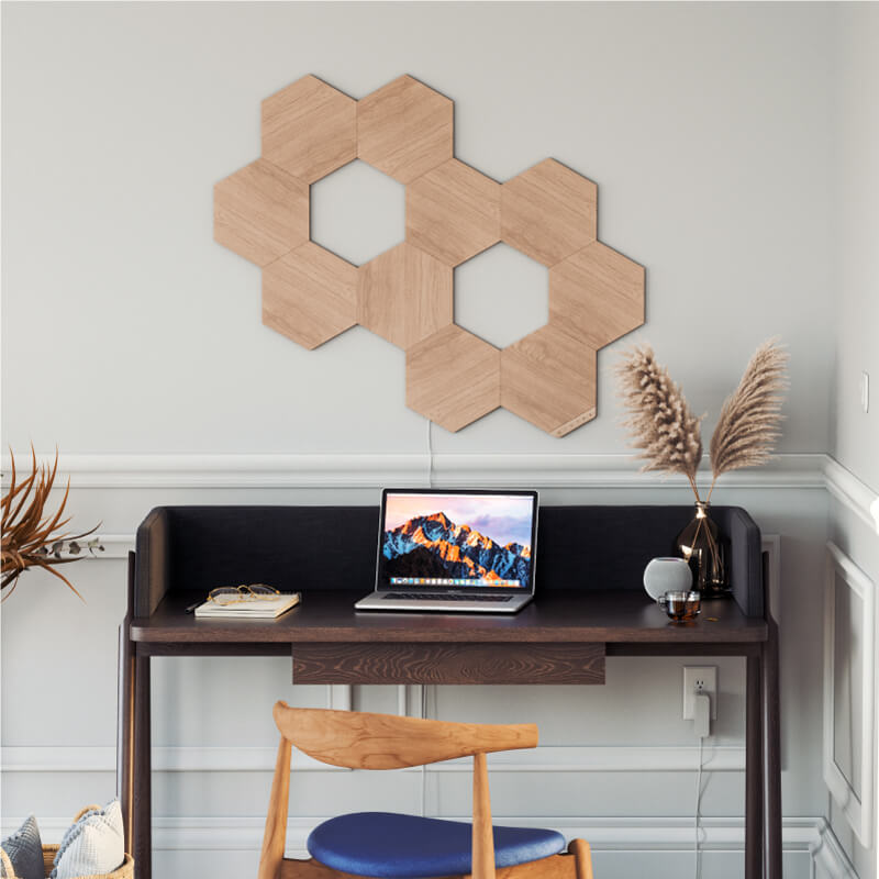 Nanoleaf Elements Thread enabled wood look hexagon smart modular light panels mounted to a wall in a home office. HomeKit, Google Assistant, Amazon Alexa, IFTTT.
