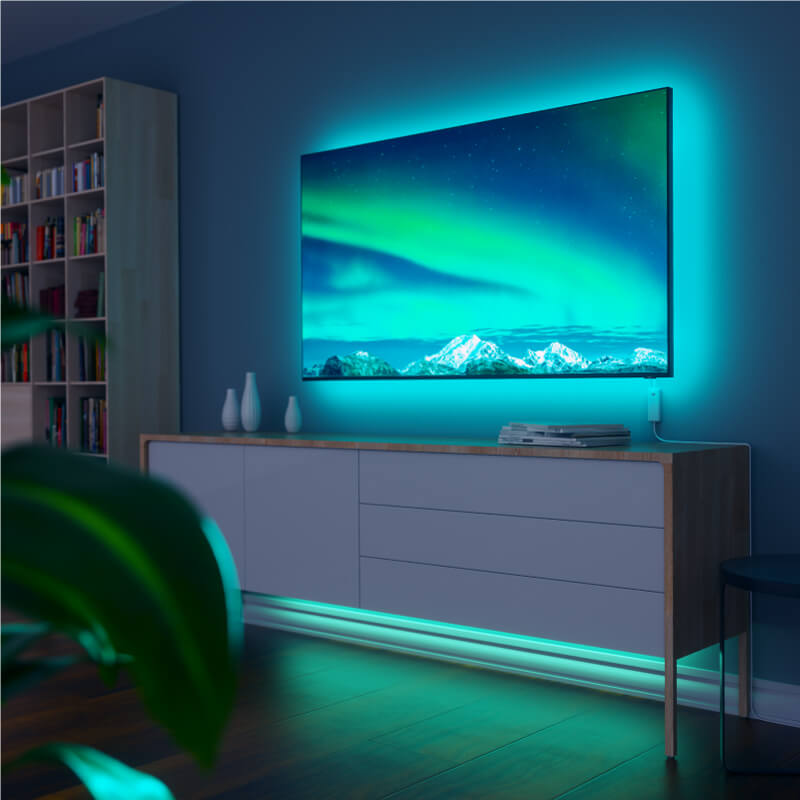 Nanoleaf Essentials Thread enabled color changing smart light strip mounted to a TV in a living room. Similar to Twinkly, Wyze. HomeKit, Google Assistant, Amazon Alexa, IFTTT.