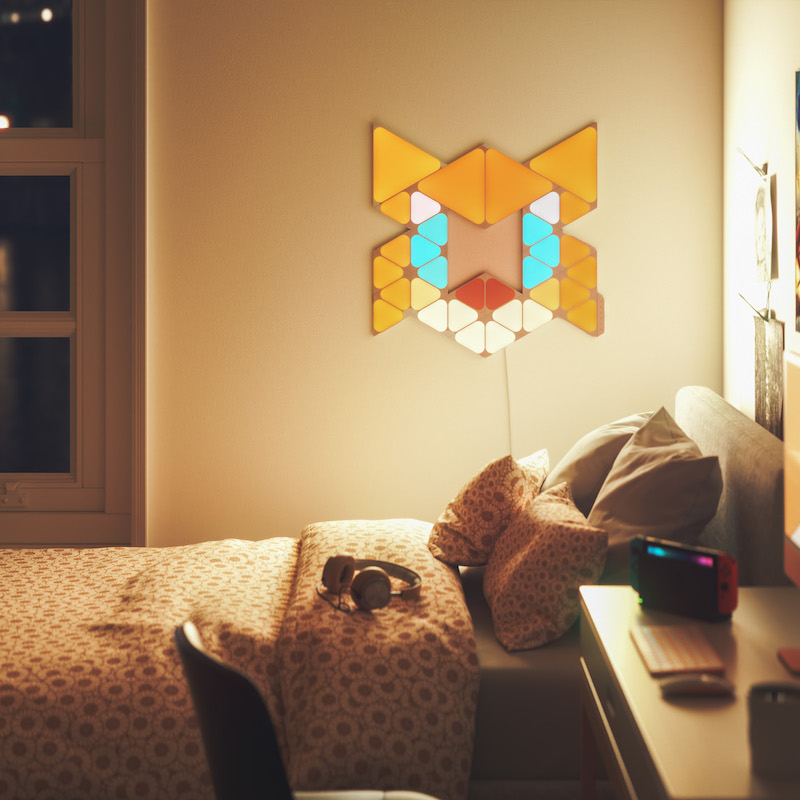 Nanoleaf Shapes Thread enabled color changing triangle and mini triangle smart modular light panels mounted to a wall in a bedroom as Tails. Sonic the Hedgehog 2. Similar to Philips Hue, Lifx. HomeKit, Google Assistant, Amazon Alexa, IFTTT.
